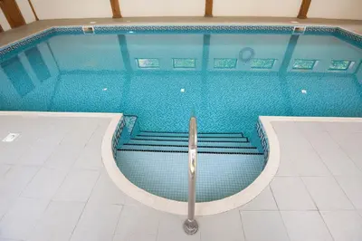 a swimming pool with stairs in the middle of it at Green Acres Cottages in Par
