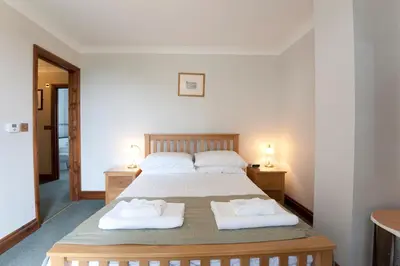 a bedroom with a bed with two towels on it at Green Acres Cottages in Par