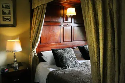 a bedroom with a bed with a wooden headboard at TOWNHOUSE ROOMS in Truro