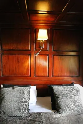 a bedroom with a bed with a wooden headboard at TOWNHOUSE ROOMS in Truro