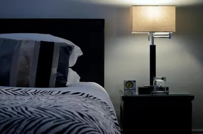 a bedroom with a bed and a lamp on a night stand at TOWNHOUSE ROOMS in Truro