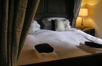 a bedroom with a bed with two towels on it at TOWNHOUSE ROOMS in Truro