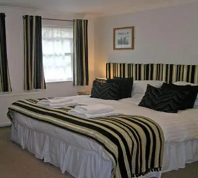 a large bed in a room with a window at TOWNHOUSE ROOMS in Truro