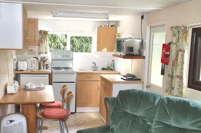 a kitchen with a couch and a table in a room at The Chalet at Mellowvean in St. Agnes