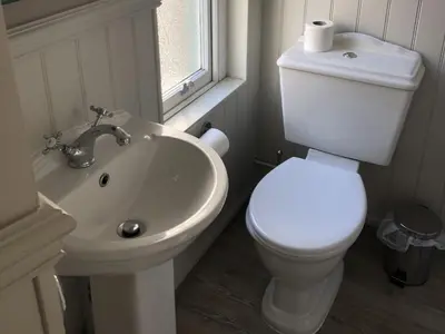 a white bathroom with a toilet and a sink at The Cornubia Inn in Hayle