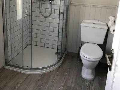 a bathroom with a toilet and a glass shower at The Cornubia Inn in Hayle