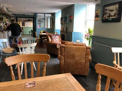 a living room with a couch and tables and chairs at The Cornubia Inn in Hayle