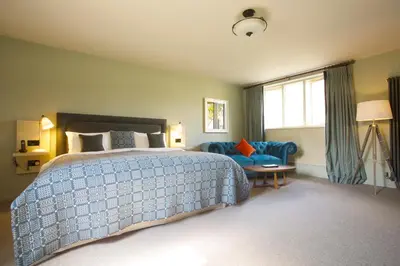 a bedroom with a bed and a couch and a window at The Plume of Feathers in Mitchell