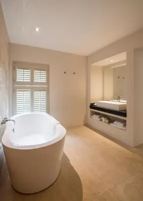 a large bathroom with a tub and a sink at The Plume of Feathers in Mitchell