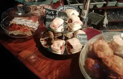 a table with several trays of food on it at The House on the Props in Polperro