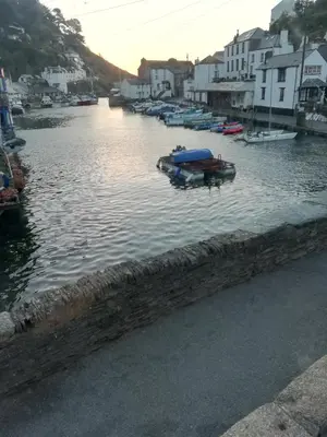 a group of boats in a river with houses at The House on the Props in Polperro