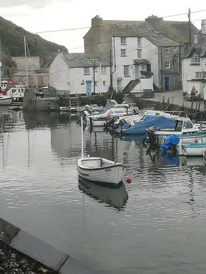 a group of boats are docked in a harbor at The House on the Props in Polperro