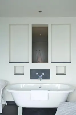 a white bath tub in a bathroom with a mirror at The Lewinnick Lodge in Newquay