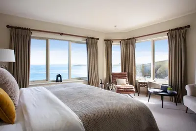 a bedroom with a bed with a view of the ocean at The Lewinnick Lodge in Newquay