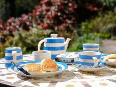 a table with plates of biscuits and cups on it at The Patio Flat in Bodmin