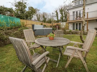 a table with four chairs and a table with a plant at Crift Farm Cottage in Bodmin