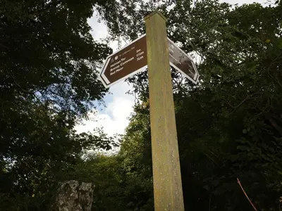 a wooden pole with two street signs on it at Crift Farm Cottage in Bodmin