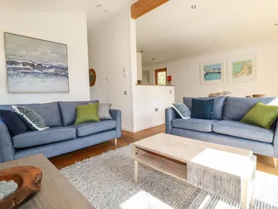a living room with blue couches and a coffee table at 4 Water's Edge in Looe
