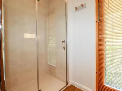 a shower with a glass door in a bathroom at 4 Water's Edge in Looe