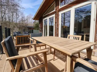 a wooden picnic table and chairs on a patio at 4 Water's Edge in Looe