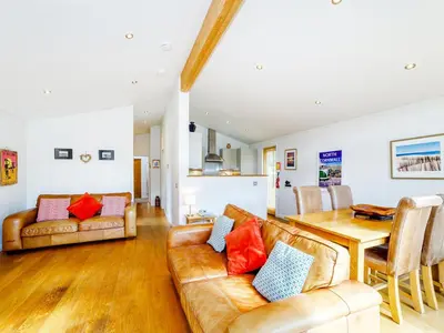 a living room with a couch and a table at 2 Water's Edge in Looe