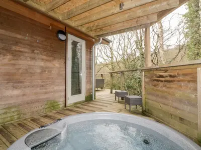 a jacuzzi tub on the deck of a cabin at 9 Stonerush Valley in Looe