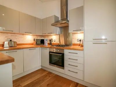 a kitchen with white cabinets and a stove top oven at 9 Stonerush Valley in Looe