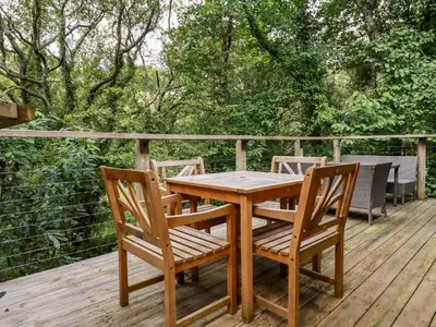 a wooden table and chairs on a deck at 9 Stonerush Valley in Looe