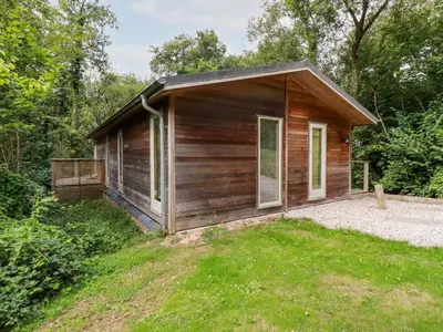 a small wooden cabin in the middle of a yard at 9 Stonerush Valley in Looe