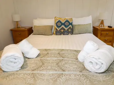 a bedroom with a bed with towels on it at 2 Stonerush Valley in Looe