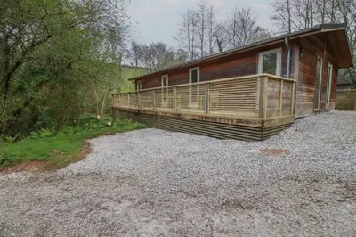 a log cabin with a porch on a pile of gravel at 2 Stonerush Valley in Looe