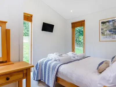 a bedroom with a bed with two laptops on it at 8 Streamside in Looe