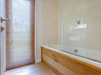 a bathroom with a bath tub and a window at 8 Streamside in Looe