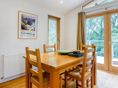 a dining room with a wooden table and chairs at 8 Streamside in Looe