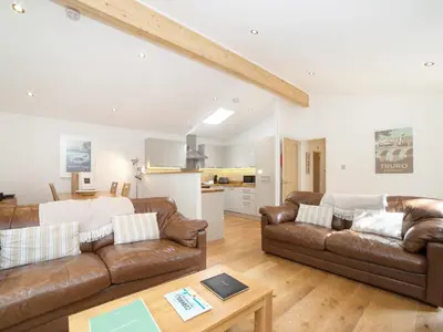 a living room with two brown leather couches and a table at 7 Streamside in Looe