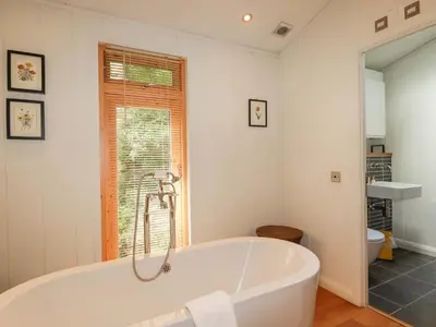 a white bath tub in a bathroom with a window at 4 Stonerush Valley in Looe
