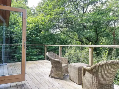 two wicker chairs sitting on a wooden deck at 4 Stonerush Valley in Looe
