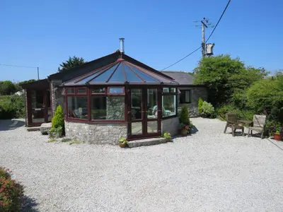 a small house with a gravel yard at Sheila's Cottage in Penryn