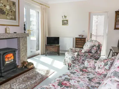 a living room with a couch and a fireplace at Sheila's Cottage in Penryn