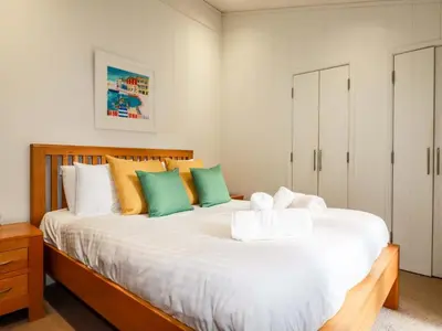 a bedroom with a large white bed with colorful pillows at 6 Streamside in Looe