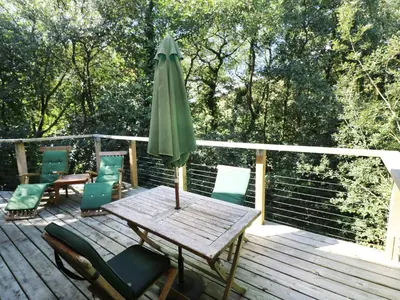 a wooden deck with a table and an umbrella at 6 Streamside in Looe