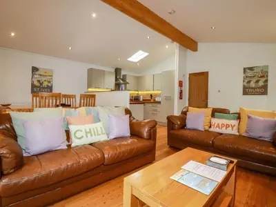a living room with two brown leather couches and a table at 6 Streamside in Looe