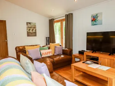 a living room with a couch and a flat screen tv at 6 Streamside in Looe