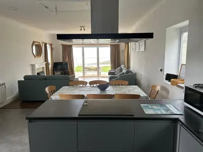 a kitchen and living room with a table and chairs at Treleigh in Hayle