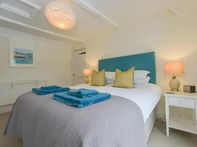 a bedroom with a bed with blue towels on it at The Shell Seekers in Fowey