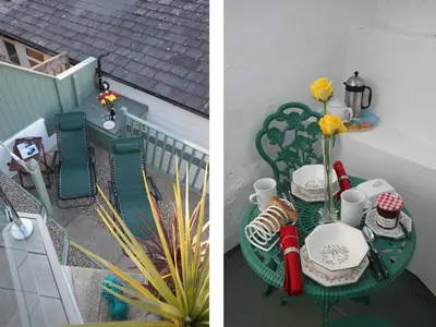a table with chairs and a vase of flowers on it at The Shell Seekers in Fowey