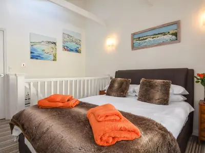 a bedroom with two beds with orange towels on them at Serendipity in Fowey