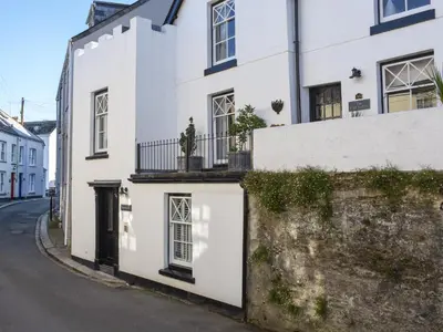 a white house on the side of a street at Serendipity in Fowey