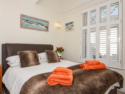 a bedroom with a bed with orange towels on it at Serendipity in Fowey