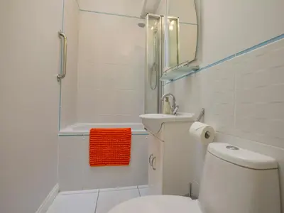 a bathroom with a toilet and a sink and a mirror at Serendipity in Fowey